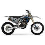 Off-road dirt bike left-side view in blue and gray with black seat and decals