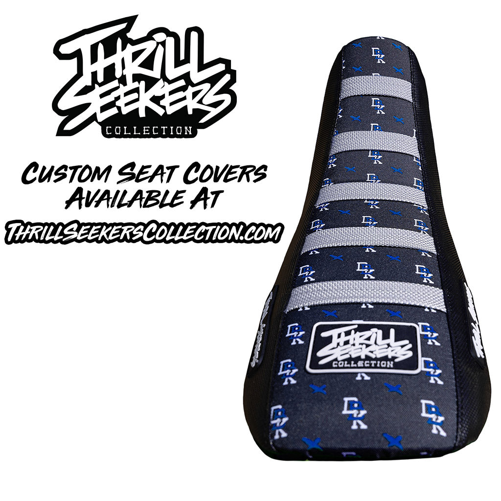 Black motocross seat cover with blue pattern, striped center, and Throttle Seekers logo